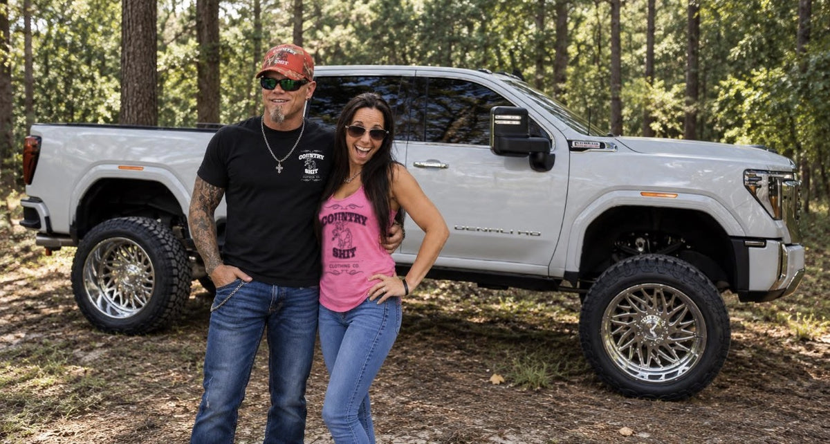 Aimee and her husband in front of their white truck